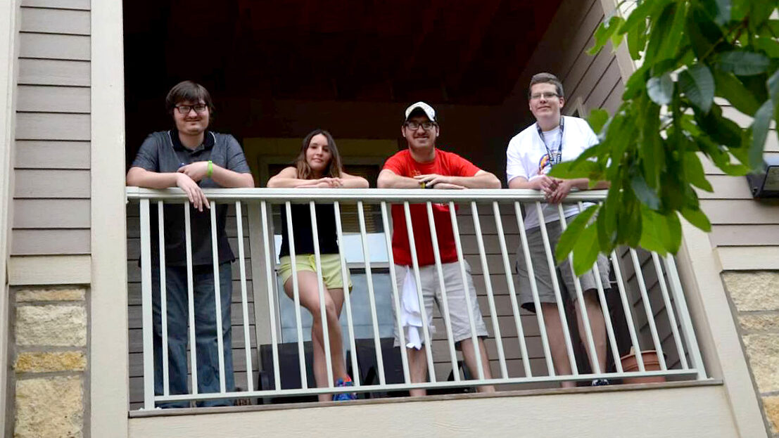 Adults with I/DD smiling on apartment balcony