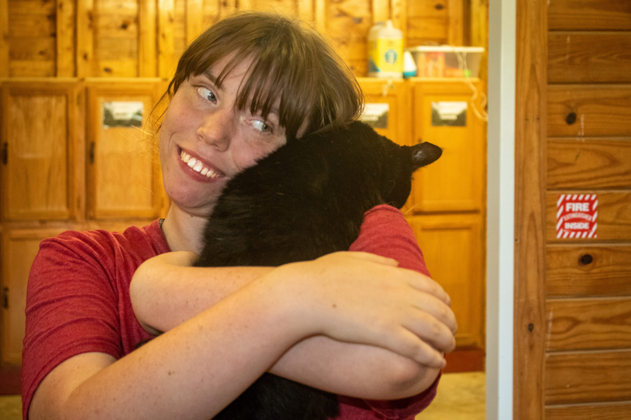 woman hugs a cat and smiles